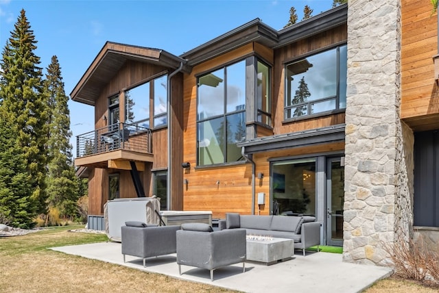 427 Whispering Pines Cir, Blue River, CO 80424 - back of property with a balcony, an outdoor living space with a fire pit, and a patio