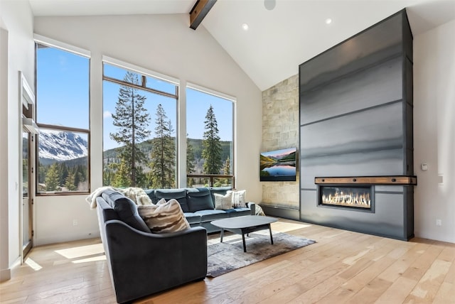 427 Whispering Pines Cir, Blue River, CO 80424 - living area with hardwood / wood-style floors, beam ceiling, a glass covered fireplace, high vaulted ceiling, and recessed lighting