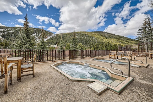 22714 US Highway 6 Unit 5945, Keystone, CO 80435 - view of swimming pool featuring a mountain view, a patio area, an in-ground hot tub, and a view of trees