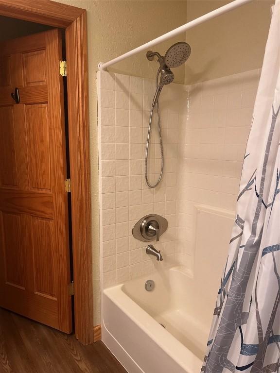 22714 US Highway 6 Unit 5945, Keystone, CO 80435 - bathroom featuring shower / tub combo with curtain and wood finished floors