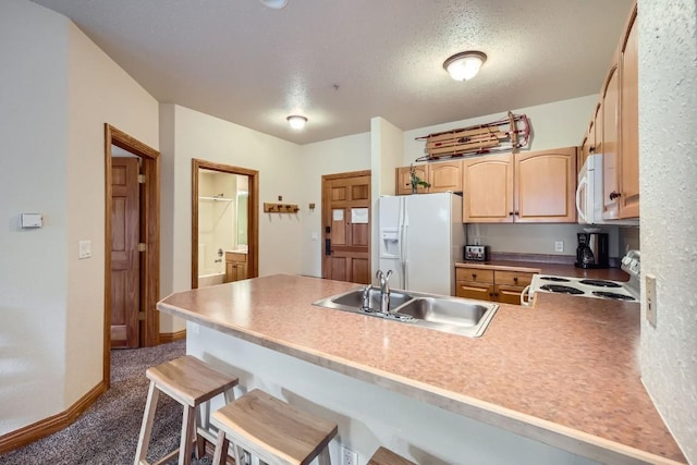 22714 US Highway 6 Unit 5945, Keystone, CO 80435 - kitchen with white appliances, a peninsula, a kitchen breakfast bar, and light brown cabinetry
