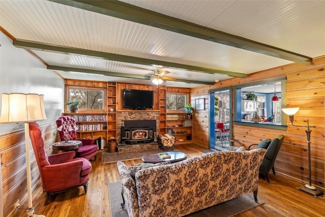 399 E Jefferson Ave, Hayden, CO 81639 - living area featuring a wood stove, wooden walls, hardwood / wood-style flooring, beamed ceiling, and plenty of natural light
