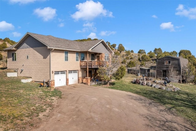 3692 County Road 7, Craig, CO 81625 - view of side of home with asphalt driveway, an attached garage, a lawn, and a balcony