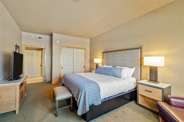 bedroom featuring light carpet, visible vents, and a closet