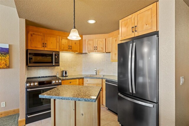 kitchen featuring a center island, a textured ceiling, decorative backsplash, light brown cabinets, and appliances with stainless steel finishes