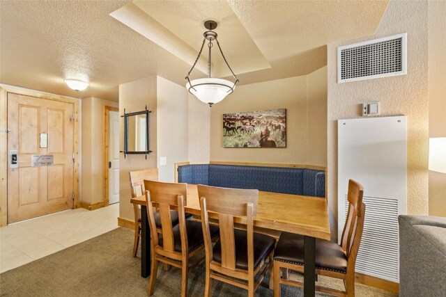 dining area featuring baseboards, tile patterned floors, a textured ceiling, and visible vents