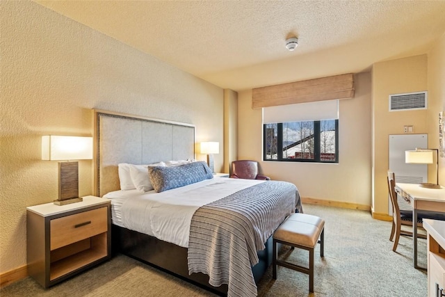 bedroom featuring light carpet, a textured ceiling, baseboards, visible vents, and a textured wall