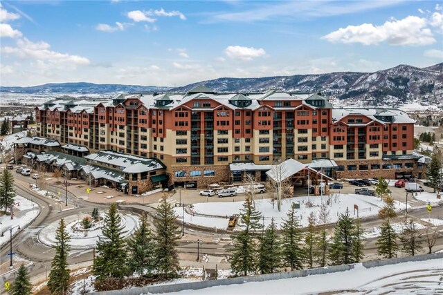 snow covered building featuring a mountain view