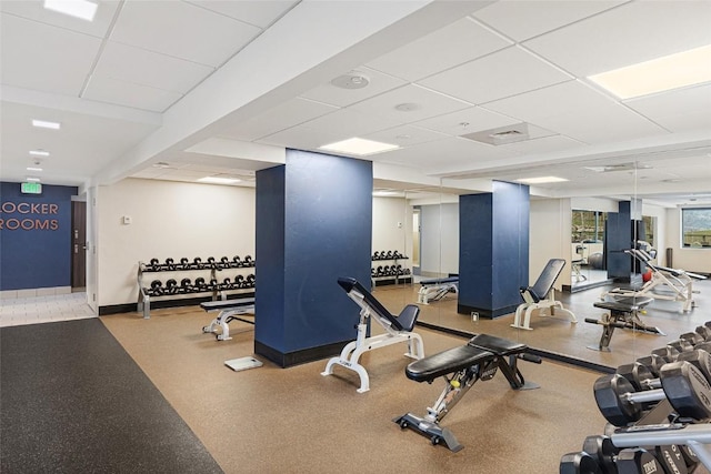gym with baseboards and a paneled ceiling