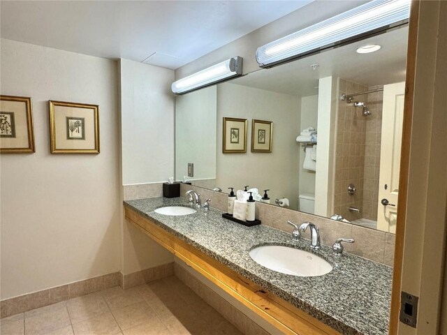 bathroom with tile patterned floors, baseboards, a sink, and toilet
