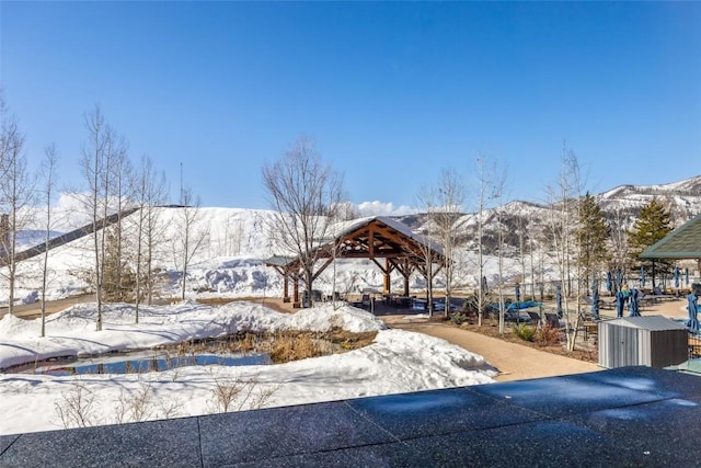 view of property's community with a gazebo, a mountain view, a storage shed, and an outdoor structure