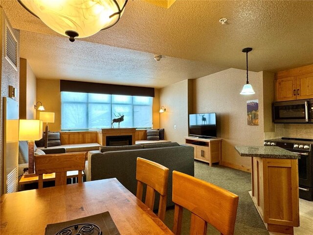 kitchen featuring stainless steel microwave, a textured ceiling, electric range, and visible vents