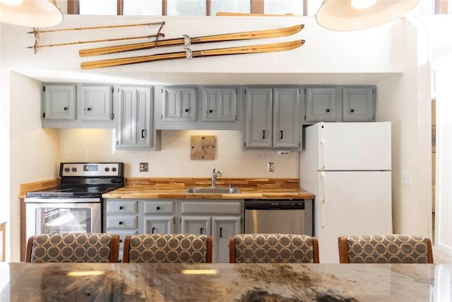 1173 Ski Hill Rd Unit 131, Breckenridge, CO 80424 - kitchen featuring appliances with stainless steel finishes, a sink, butcher block countertops, and gray cabinetry