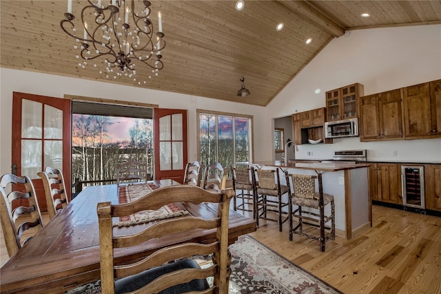 dining area featuring beverage cooler, light wood finished floors, wooden ceiling, beamed ceiling, and high vaulted ceiling
