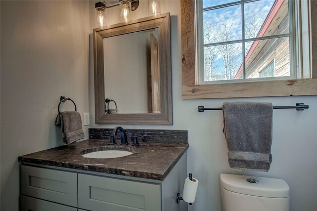 half bathroom featuring toilet and vanity
