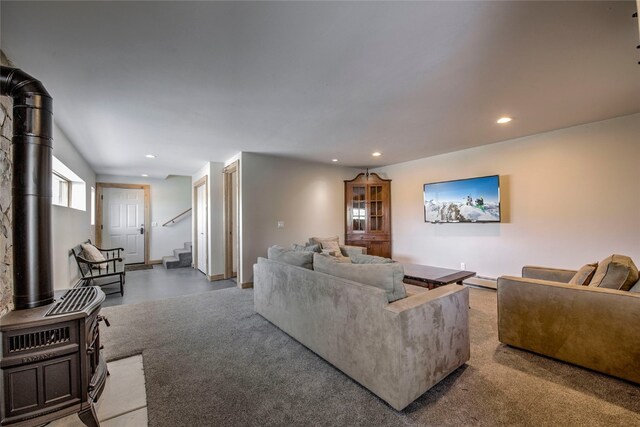 living area with recessed lighting, stairs, and a wood stove