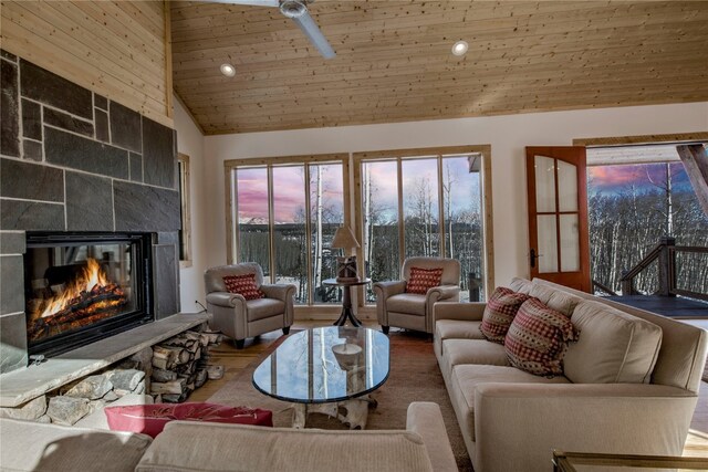 living area with recessed lighting, vaulted ceiling, wood finished floors, wooden ceiling, and a tiled fireplace
