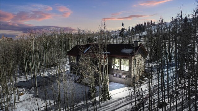 view of snowy exterior featuring a chimney and crawl space