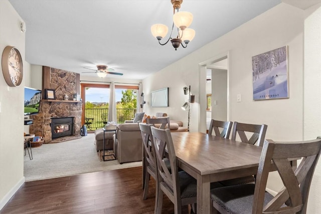 2350 Ski Trail Ln Unit 313, Steamboat Springs, CO 80487 - dining space featuring wood finished floors, a stone fireplace, a ceiling fan, a chandelier, and baseboards