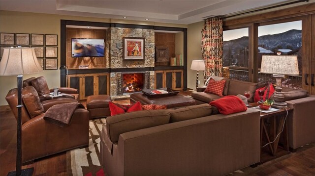 2250 Apres Ski Way Unit R-702, Steamboat Springs, CO 80487 - cinema featuring wood finished floors, a stone fireplace, and a raised ceiling