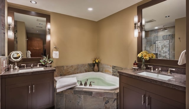 full bath featuring a garden tub, two vanities, a sink, and a stall shower