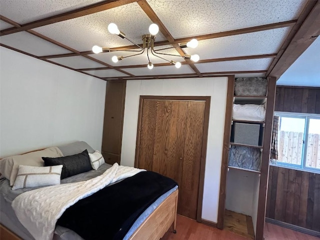 1325 Dream Island Plz Unit 55, Steamboat Springs, CO 80487 - bedroom featuring wood finished floors, a chandelier, and wood walls