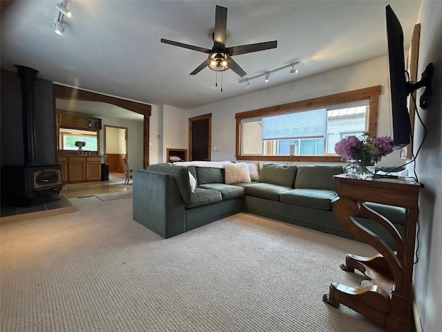 1325 Dream Island Plz Unit 55, Steamboat Springs, CO 80487 - living room featuring rail lighting, ceiling fan, a wood stove, and light carpet