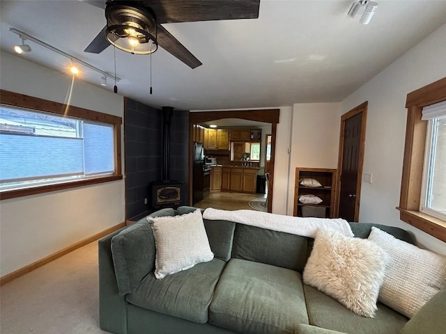 1325 Dream Island Plz Unit 55, Steamboat Springs, CO 80487 - living area featuring a ceiling fan, healthy amount of natural light, and a wood stove