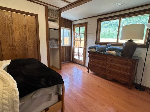 1325 Dream Island Plz Unit 55, Steamboat Springs, CO 80487 - bedroom with wooden walls, light wood-style floors, and access to exterior
