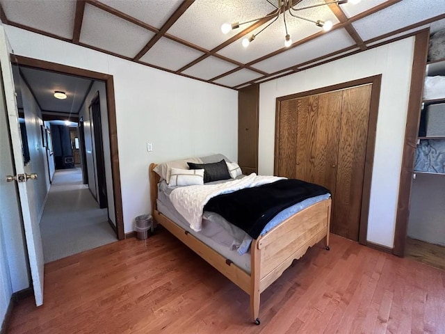 1325 Dream Island Plz Unit 55, Steamboat Springs, CO 80487 - bedroom featuring light wood-style floors, a chandelier, and a closet