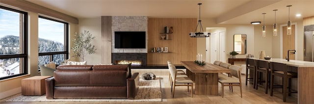 interior space with a stone fireplace, light hardwood / wood-style flooring, and a chandelier