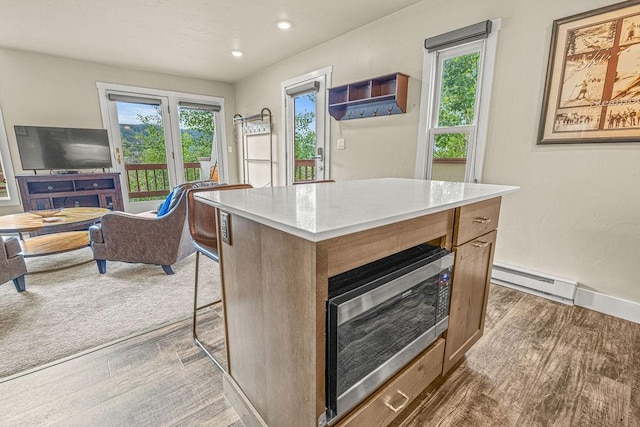 1800 Burgess Creek Rd SW Unit 209, Steamboat Springs, CO 80487 - kitchen with baseboard heating, plenty of natural light, light countertops, a kitchen island, and recessed lighting