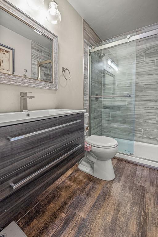 1800 Burgess Creek Rd SW Unit 209, Steamboat Springs, CO 80487 - bathroom featuring toilet, vanity, a shower stall, and wood finished floors