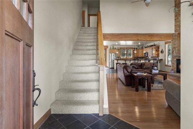 46 Sage View Ct, Dillon, CO 80435 - staircase with a high ceiling, a healthy amount of sunlight, a stone fireplace, and baseboards