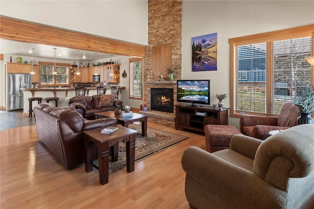 46 Sage View Ct, Dillon, CO 80435 - living area featuring light wood-type flooring, a healthy amount of sunlight, a stone fireplace, and a high ceiling