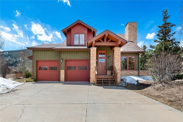 46 Sage View Ct, Dillon, CO 80435 - view of front facade featuring stone siding, a chimney, concrete driveway, and a shingled roof