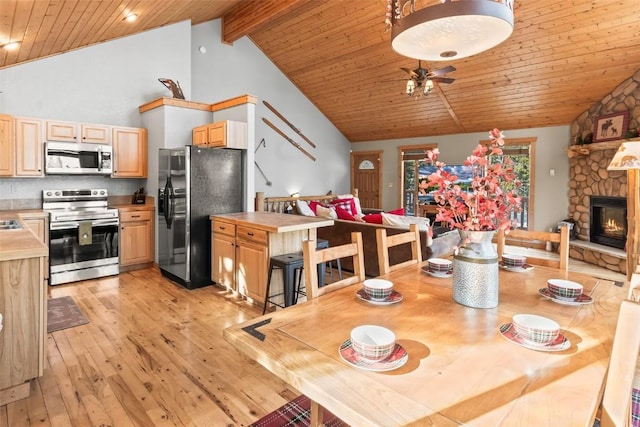 407 S Puma Pl, Fairplay, CO 80440 - dining space featuring light wood-style flooring, ceiling fan, a fireplace, wooden ceiling, and high vaulted ceiling