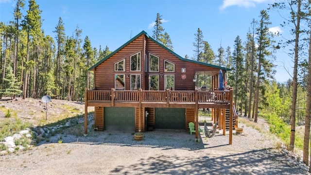 889 Venture Rd, Fairplay, CO 80440 - rustic home with log veneer siding, driveway, a deck, stairway, and an attached garage