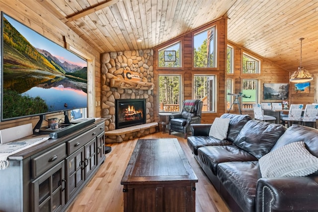 889 Venture Rd, Fairplay, CO 80440 - living area with wood ceiling, a stone fireplace, light wood-type flooring, wood walls, and high vaulted ceiling