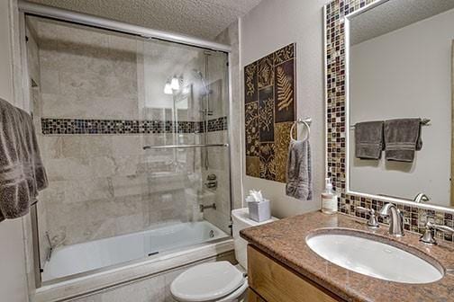 765 Columbine Rd Unit C103, Breckenridge, CO 80424 - full bathroom featuring shower / bath combination with glass door, vanity, toilet, and a textured ceiling