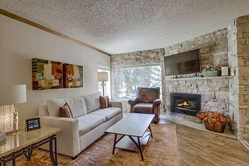 765 Columbine Rd Unit C103, Breckenridge, CO 80424 - living room featuring a textured ceiling, ornamental molding, a fireplace, and wood finished floors