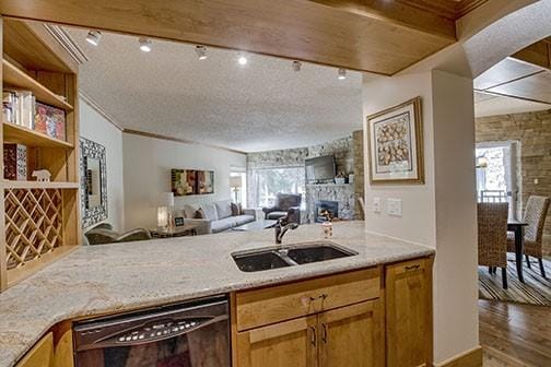 765 Columbine Rd Unit C103, Breckenridge, CO 80424 - kitchen featuring dishwasher, a sink, open floor plan, wood finished floors, and healthy amount of natural light