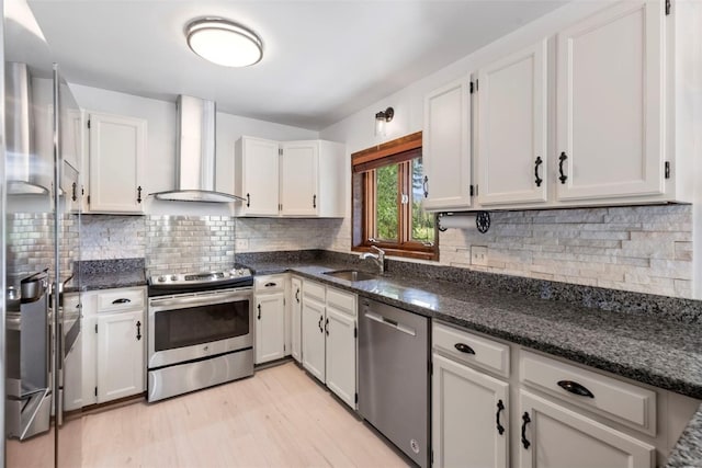 272 Doris Dr, Breckenridge, CO 80424 - kitchen with stainless steel appliances, wall chimney exhaust hood, a sink, light wood-style floors, and white cabinetry