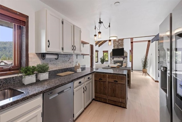 272 Doris Dr, Breckenridge, CO 80424 - kitchen with dishwasher, decorative backsplash, a stone fireplace, dark stone countertops, and open floor plan