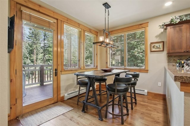 188 Tip Top Trl Unit 6558, Dillon, CO 80435 - dining area featuring a baseboard radiator, light wood-type flooring, and healthy amount of natural light