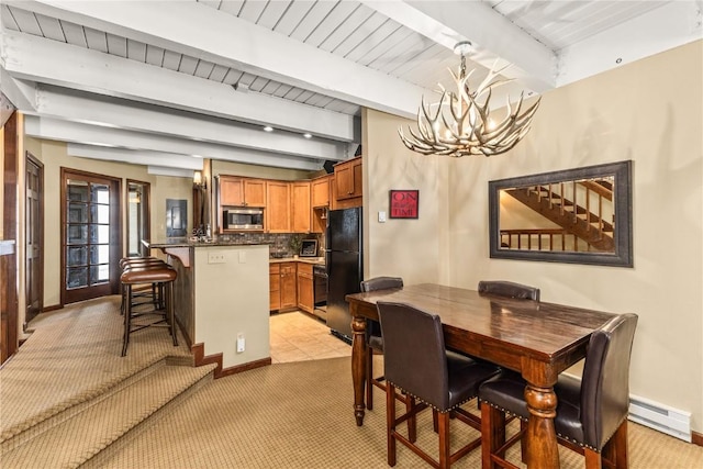 2735 Burgess Creek Rd Unit 11, Steamboat Springs, CO 80487 - dining area with a chandelier, beam ceiling, baseboards, light colored carpet, and baseboard heating