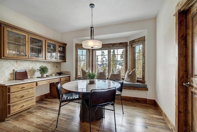 dining space featuring baseboards and hardwood / wood-style flooring