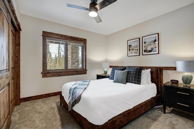 carpeted bedroom with ceiling fan and baseboards