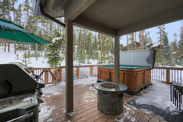 snow covered deck featuring a hot tub and area for grilling