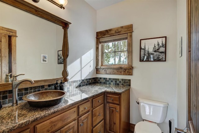 bathroom featuring backsplash, vanity, and toilet